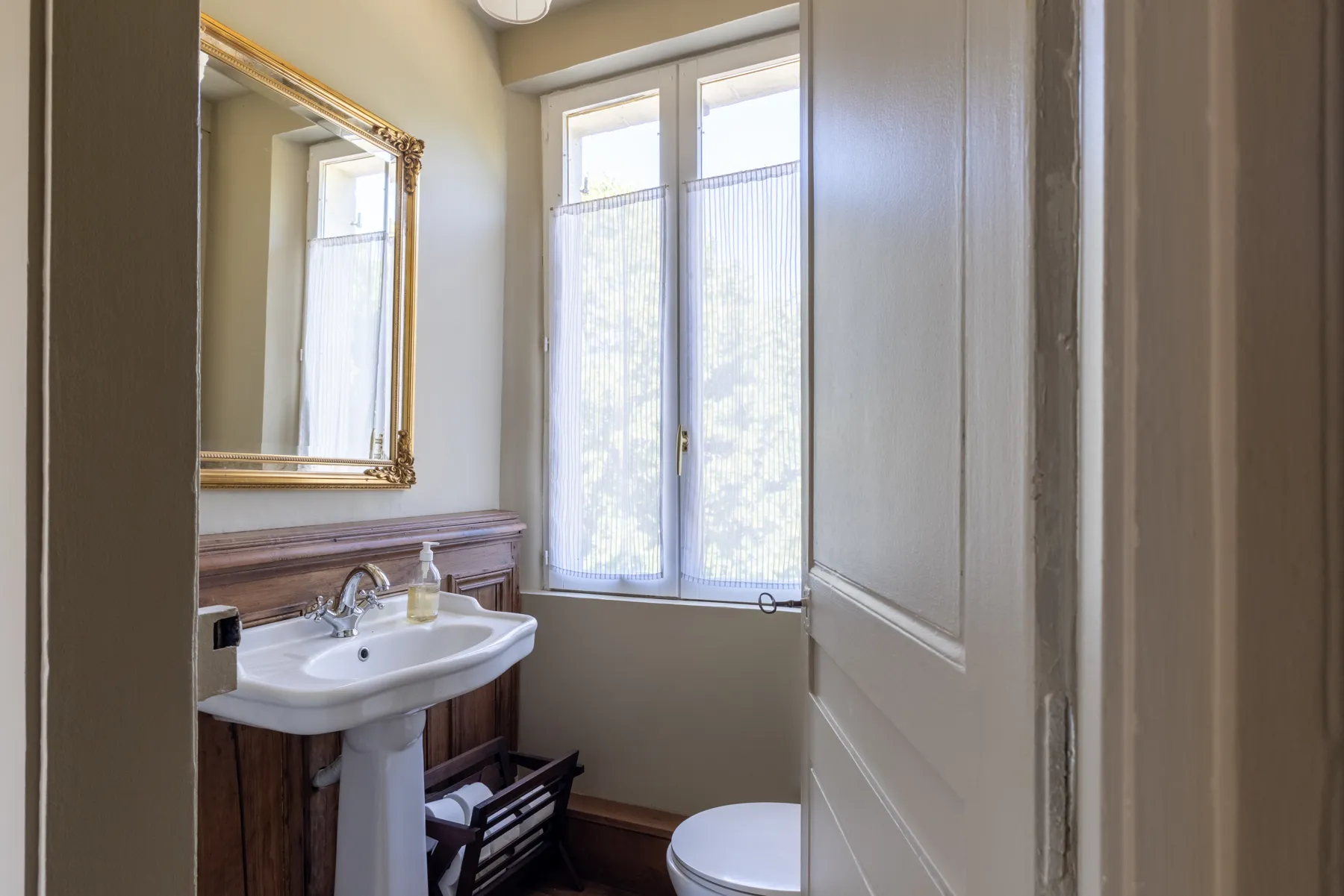 Salle d'eau au miroir doré et lavabo rétro